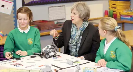  ?? — Reuters ?? British Prime Minister Theresa May sits with pupils during a visit to Captain Shaw’s Primary School in Bootle, Britain, on Wednesday.