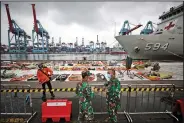  ??  ?? Navy personnel talk Thursday at the Port of Tanjung Priok in Jakarta, Indonesia, near pieces of the Sriwijaya Air jet that crashed into the Java Sea on Jan. 9. (AP/Dita Alangkara)