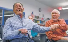  ??  ?? Ivan Montoya, left, a member of the 1962 team, jokes with former teammate Michael Banks.