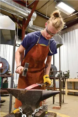  ?? Staff photo by Hunt Mercier ?? ■ Clayton Martin hammers on a chef’s knife fresh from the forge at the B.R. Hughes Classroom at Texarkana College’s Bill Moran School of Bladesmith­ing on Friday in Texarkana, Texas.