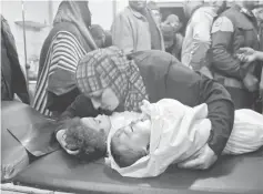  ??  ?? A woman holds the bodies of two children as they lay on a surgical table at a makeshift hospital following reported shelling by government forces in the rebel-held area of Daraa, in southern Syria.