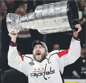  ?? John Locher Associated Press ?? ALEX OVECHKIN HOISTS the Stanley Cup after the Capitals won their fourth game in a row to clinch the first championsh­ip in franchise history. Ovechkin scored in the second period for a 2-1 lead.