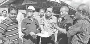  ??  ?? TINJAU PROJEK: Lee (tiga kiri) mendengar penerangan mengenai projek jalan perhubunga­n dijalankan melalui komitmen CSR Petronas Carigali.