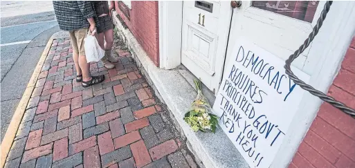  ?? DANIEL LIN/DAILY NEWS-RECORD VIA THE ASSOCIATED PRESS ?? Passersby examine the menu at the Red Hen Restaurant in Virginia. Was the restaurant justified in booting Sarah Huckabee Sanders because she works for Trump?