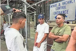  ?? BOBBY CAINA CALVAN/AP FILE ?? Axel Coronado, center, listens to a conversati­on between brothers Leonardo Oviedo, left, and Angel Mota on Aug. 10. Coronado has been staying at a New York City shelter after fleeing Venezuela.