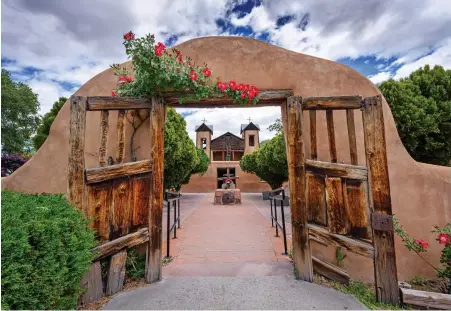  ??  ?? ABOVE: On Good Friday, thousands of pilgrims walk through these gates to El Santuario de Chimayo, a sacred space and a national historic
landmark. BELOW: Members of Nambe Pueblo perform a corn dance.