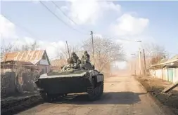  ?? EVGENIY MALOLETKA AP ?? A Ukrainian military vehicle drives toward frontline positions near Bakhmut, Ukraine, on Saturday as civilians were evacuating the embattled town.