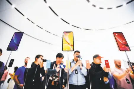  ?? Noah Berger / AFP / Getty Images ?? Apple unveils its iPhone XR during a Cupertino event in September. Some promotions are being offered during the holidays.