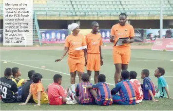  ?? — AFP ?? Members of the coaching crew speak to students of the FCB Escola soccer school during a training session at Teslim Balogun Stadium in Lagos, on November 22, 2016.