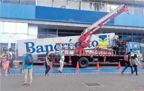  ?? BERNY BERROCAL ?? Trabajador­es retiraron, la tarde de ayer miércoles, el rótulo de Bancrédito que estaba en la sede del banco público ubicada frente al parque Central en San José. La entidad cartagines­a dejará de existir a partir del próximo 1. ° de diciembre.