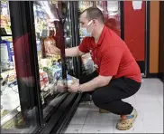  ??  ?? Ben Lehman, a night manager at Boyer’s Food Markets in Womelsdorf, stocks dairy items.