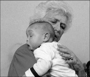  ?? DENNIS COOK / AP FILE (1989) ?? First lady Barbara Bush holds an infant identified as Donavan during a visit to Grandma’s House in Washington. Grandma’s House serves as a house for infants and small children infected with the AIDS virus. Bush died April 17 at the age of 92.