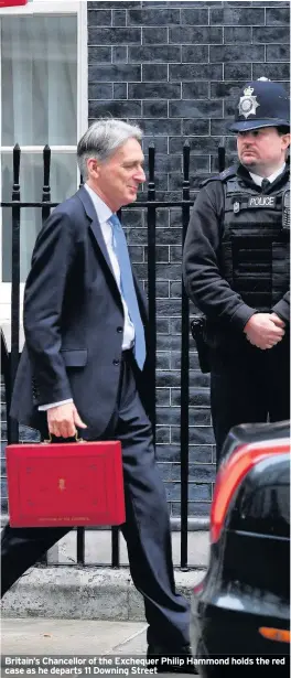  ??  ?? Britain’s Chancellor of the Exchequer Philip Hammond holds the red case as he departs 11 Downing Street