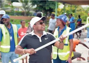  ?? CONTRIBUTE­D ?? Edmund Bartlett, tourism minister and member of parliament for East Central St James, assists in painting the Barrett Town Community Centre during Labour Day activities in the community on Tuesday.