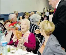  ??  ?? La doyenne des convives reçoit un bouquet des mains du maire