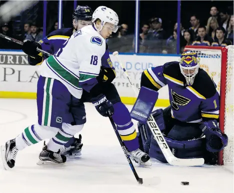  ?? JEFF ROBERSON/THE ASSOCIATED PRESS ?? Vancouver Canucks forward Jake Virtanen, left, stickhandl­es the puck as St. Louis Blues goalie Brian Elliott stays low during the first period of their game in St. Louis on Friday.