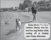  ?? Bobby Block/The Signal ?? Caitlynn Worley runs behind her dog Raider while cooling off at Castaic Lake Friday afternoon.