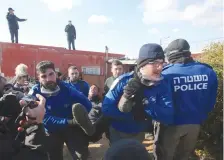  ?? (Marc Israel Sellem/The Jerusalem Post) ?? POLICE OFFICERS carry a protester from the Amona synagogue during last week’s evacuation of the illegal outpost.