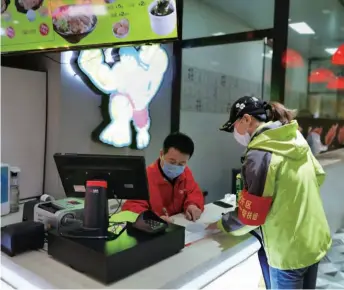  ??  ?? A staff from Tianjin Municipal Bureau of Financial Affairs checks the situation in a shopping mall on April 9 after it reopened