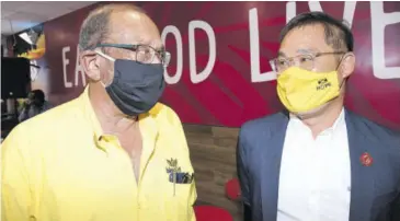  ?? (Photos: Joseph Wellington) ?? Former Private Sector Organisati­on of Jamaica president and prominent businessma­n Howard Mitchell (left) has a word with Michael Lyn Jr, chief innovation officer at Island Grill, at the opening of the restaurant chain’s new store in downtown Kingston yesterday.