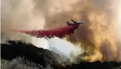  ?? RINGO H.W. CHIU AP ?? An air tanker drops retardant on a wildfire in Goleta, California, on Oct. 13, as firefighte­rs make progress battling the wildfires in Southern California.