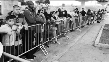  ?? AP PHOTO/ELLIOT SPAGAT ?? In this Sept. 26, 2019, file photo, asylum seekers, in Tijuana, Mexico, listen to names being called from a waiting list to claim asylum at a border crossing in San Diego.