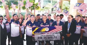  ??  ?? Loke receiving a cheque for Tabung Harapan from the Porsche Owners Club Malaysia at his ministry.