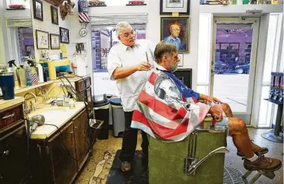  ?? Elizabeth Conley / Staff photograph­er ?? A few months ago, a homeless person damaged the windows of Shepard Barber Shop, where Leon Apostolo works.