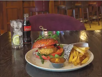  ??  ?? Falafel Burger, hummus, rocket and mango chutney on a beetroot brioche bun and fries.