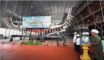  ??  ?? Number three: A foundation-laying ceremony is under way with the hull of the Royal Malaysian Navy’s third Littoral Combat Ship (LCS3) at the RMN base in Lumut. — Bernama