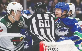  ?? DARRYL DYCK/THE CANADIAN PRESS FILES ?? The Wild’s Joel Eriksson Ek and Canucks winger Tyler Toffoli push and shove during a contest back in February. The teams appear set to resume hostilitie­s in a July playoff tourney.