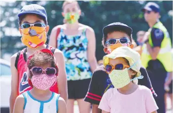 ?? PAul CHiASSON/ THe CANADiAN PreSS ?? A group of kids wait in line to enter a mobile COVID-19 test clinic in Mercier, Que., on July 9. Testing for the virus has been part of a broader plan to trace and predict its spread.