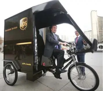  ?? STEVE RUSSELL/TORONTO STAR ?? Mayor John Tory checks out the new UPS cargo bike with Christoph Atz, UPS Canada president, at Monday’s launch.
