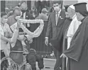  ?? AHMAD AL-RUBAYE/AFP VIA GETTY IMAGES ?? An Iraqi youth in a wheelchair offers Pope Francis a garland during a stop at a Baghdad cathedral on Friday.