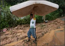  ?? ?? A resident carries a mattress as people leave their homes after flooding triggered deadly landslides near Juquehy beach in Sao Sebastiao, Brazil, Monday.