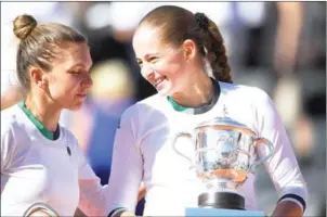  ?? LIONEL BONAVENTUR­E/AFP ?? Romania’s Simona Halep (left) congratula­tes Jelena Ostapenko after the Latvian won the 2017 French Open final at Roland Garros on June 10 in Paris.