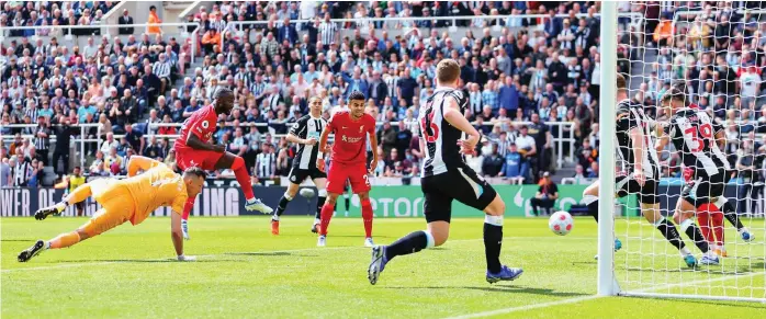  ?? GETTY IMAGES ?? Nabbing a victory: Keita (left) pounces to thread a shot through the Newcastle defenders on the line and score the decisive goal for Liverpool