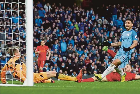  ?? REUTERS PIC ?? Manchester City’s Sergio Aguero (right) scores in their Premier League match against Liverpool at the Etihad Stadium on Sunday.