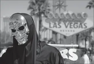  ?? Associated Press photos ?? Oakland Raiders fan Sebastian Bodden, wearing a skull mask, attends an NFL football draft event Saturday in Las Vegas. The team will move to Las Vegas in 2020.