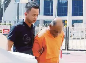  ?? PIC BY RAMDZAN MASIAM ?? The suspect being led to the Penang Court Complex in George Town yesterday.