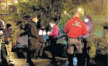  ??  ?? Agentes de la Policía Foral identifica­n a varias personas en los alrededore­s de un parque pamplonés.