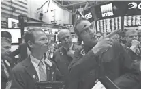  ??  ?? Gregory Rowe, right, speaks Tuesday on the floor of the New York Stock Exchange while waiting for Spotify’s IPO. RICHARD DREW/AP