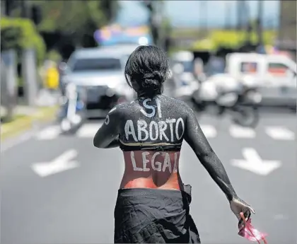  ?? Jose Cabezas AFP/Getty Images ?? A WOMAN marches in a San Salvador protest. Internatio­nal rights groups have urged the country to review its abortion ban.