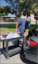  ?? COURTESY PHOTO ?? Larry Reynolds loads food into a car for a family at the Peace Center of Sunrise Church in Ontario. The church’s food pantry offers food noon-3p.m. Monday through Friday.