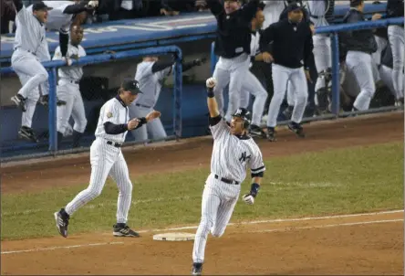  ?? BILL KOSTROUN ?? FIEE - In this Oct. 31, 2001, file photo, New York Yankees’ Derek Jeter celebrates his game-winning home run in the 10th inning as he rounds first base in Game 4of baseball’s World Series against the Arizona Diamondbac­ks at Yankee Stadium in New York. Jeter could be a unanimous pick when Baseball Hall of Fame voting is announced Tuesday.