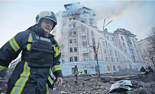  ?? ?? Firefighte­rs work to put out a blaze in a block of flats hit by burning debris from the intercepte­d Russian missiles