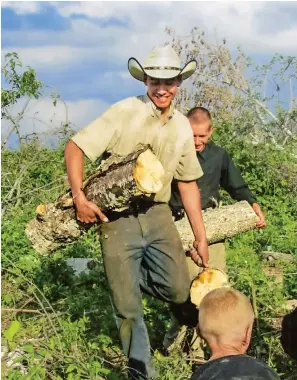  ??  ?? The farm’s menagerie grows when kittens are born. Jedd and Dale (above) move firewood while the others feed the cattle (below).