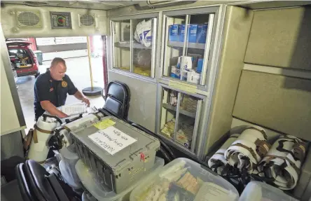  ?? PHOTOS BY DORAL CHENOWETH/COLUMBUS DISPATCH ?? Columbus Division of Fire Capt. Aaron Renner looks through a box of medical supplies Tuesday inside the special mass casualty ambulance, which is kept in Downtown Fire Station No. 1.