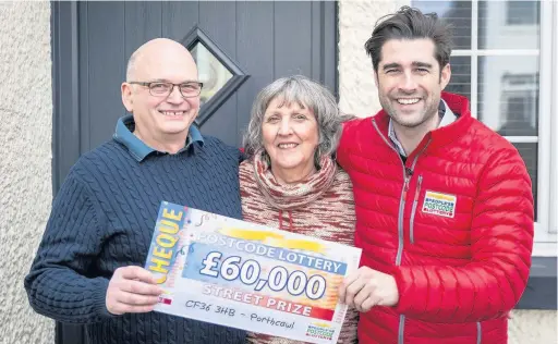  ??  ?? Andrew Staley, of Victoria Avenue, Porthcawl, and wife Anne are presented with a cheque for £60,000 by People’s Postcode Lottery Ambassador Matt Johnson