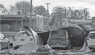  ?? ?? Cars in the Voyager parking lot were covered by roofing material. City Manager Joseph Gacioch also said most of the damage was limited to a section of east 9 Mile and north Hilton Road – the majority of the city even maintained power.